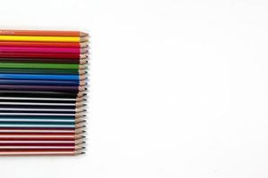 vista superior del grupo de lápices de colores en el grupo trasero blanco. concepto de regreso a la escuela para vector de diseño moderno, ilustración y uso en la plantilla de diseño de página web foto
