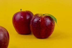 Two red apples isolated on yellow background. Two fresh apples fruits used for healthy food concept photo