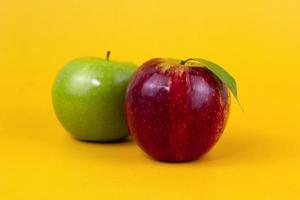 manzanas rojas y verdes aisladas sobre fondo amarillo. dos manzanas frescas usadas para el concepto de alimentos saludables y para el diseño de manzanas dietéticas foto