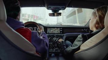 uma mulher regula a temperatura dentro de um carro Bentley, dirigindo pela cidade video