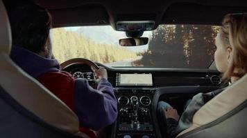 um passageiro fotografa uma estrada florestal de um carro Bentley video