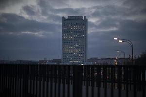 edificio de oficinas en la ciudad por la noche. las ventanas brillan en la casa. foto