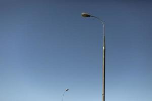 Pillar against sky. Lighting fixture in city. Pole with lamp. photo