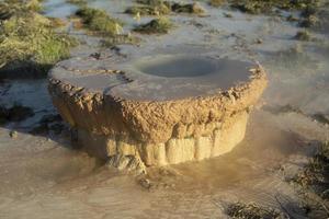 Rusty pipe in ground. Polluter. Evaporation of hot water. photo