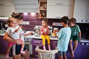 madre con hijos cocinando en la cocina, momentos felices de los niños. foto