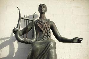 estatua con arpa. antigua diosa griega hecha de bronce. estatua de ninfa. foto