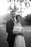 young couple the groom in a black suit and the bride in a white short dress photo