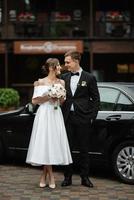 young couple bride and groom in a white short dress photo