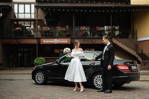 young couple bride and groom in a white short dress photo