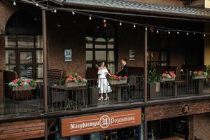 young couple bride and groom in a white short dress photo