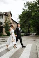 young couple bride and groom in a white short dress photo