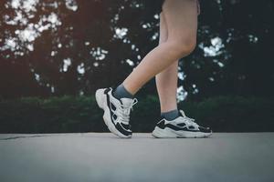 Side view of athletic Women in running start pose on running track in the garden street. Sport and running concept. photo