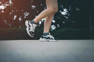 Side view of athletic Women in running start pose on running track in the garden street. Sport and running concept. photo