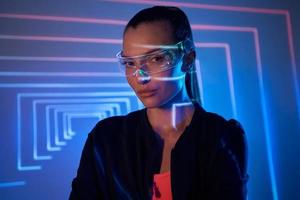 Beautiful young woman in futuristic glasses looking at camera photo