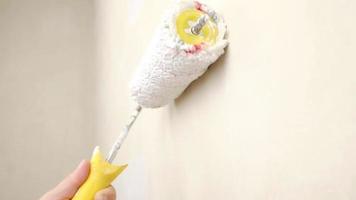 måla väggen med en vit roller. högkvalitativ fullhd-film video