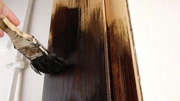 varnishing a wooden door with a brush dark paint video