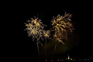 Fuegos artificiales enormes y coloridos sobre los campos de arroz al anochecer. foto