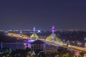 la apertura de la luz para decorar el puente que cruza el río chao phraya en tailandia, puente iluminado con led, tráfico en el puente sobre el río foto