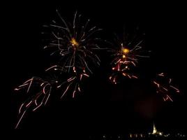 Fuegos artificiales enormes y coloridos sobre los campos de arroz al anochecer. foto