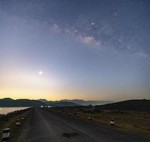 Twilight morning light Before sunrise At the reservoir, straight road ahead over the dam, the Milky Way in the early morning photo