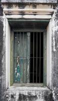 viejas ventanas de madera en las viejas paredes de yeso hay una protección de acero contra la intrusión. foto