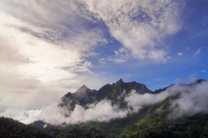 Green mountain scenery There is a mist in the mountains . The sky is blue and the clouds are white. photo