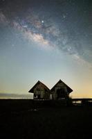 Milky Way , old abandoned house, red roof on open field photo