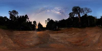 panorama vr360, la vía láctea sobre la sombra del árbol durante el crepúsculo antes del amanecer, pagoda en la cima de la colina foto