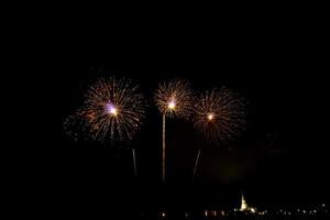 Fuegos artificiales enormes y coloridos sobre los campos de arroz al anochecer. foto