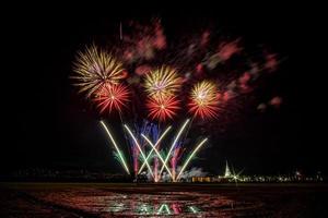 Huge, colorful fireworks over the rice fields at dusk. photo