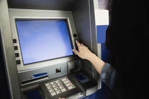 People waiting to get money from automated teller machine - people withdrawn money from ATM concept photo