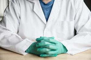 Middle part of doctor sitting and put green glove showing thumb up cheer sign photo