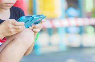 Kid is playing game in mobile phone with colorful background photo