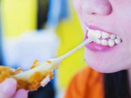 Woman is going to eat sticky stretch fried cheese ball photo