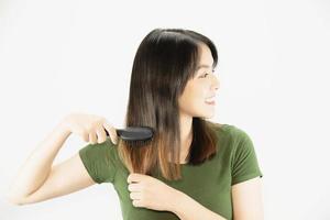 Young beautiful lady happy using comb to straight her hair - woman beauty hair care concept photo