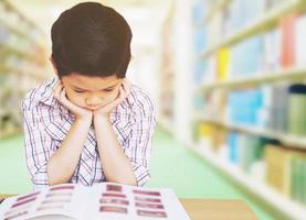 un niño no está feliz haciendo la tarea en la escuela foto