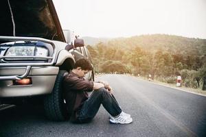 Man try to fix a car engine problem on a local road Chiang mai Thailand - people with car problem transportation concept photo