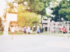 Blurred photo of Asian children are playing basketball with warm sun light from top right corner