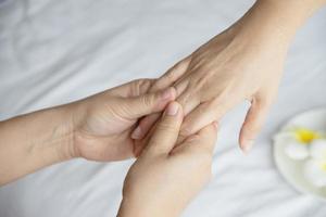 Hand spa massage over clean white bed background - people relax with hand massage service photo