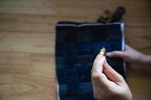 mujer vintage cosiendo tela a mano con bordados sobre fondo de mesa de madera - gente y concepto de tareas domésticas hechas a mano foto