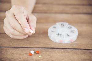 People prepare daily medicine tablet in pillbox - people healthcare with medicine pills concept photo