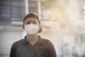 Man wearing mask protect fine dust in air pollution environment - people with protection equipment for air pollution concept photo