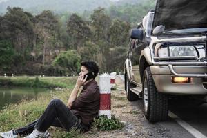 el hombre trata de arreglar un problema de motor de automóvil en una carretera local chiang mai tailandia - personas con concepto de transporte de problemas de automóvil foto