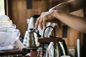 Man making drip fresh coffee in vintage coffee shop with green nature background - people with fresh coffee in nature concept photo