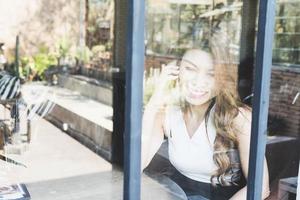 Lady happily using mobile phone in coffee shop photo