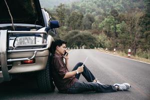 Man try to fix a car engine problem on a local road Chiang mai Thailand - people with car problem transportation concept photo