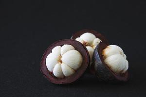 Mangosteen Thai popular fruits - a tropical fruit with sweet juicy white segments of flesh inside a thick reddish-brown rind. photo