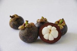 Mangosteen Thai popular fruits - a tropical fruit with sweet juicy white segments of flesh inside a thick reddish-brown rind. photo