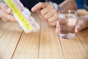 Doctor is assist patient to eat medicine tablet in pillbox correctly - people medical concept photo