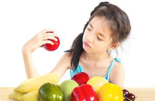 Asian girl is showing dislike vegetable expression over white background photo